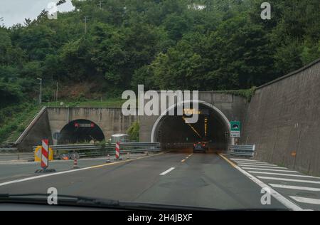 Unterirdischer Tunnel in der Stadt mit Autos fahren. Städtische Infrastruktur. Autobahn durch die Berge Stockfoto