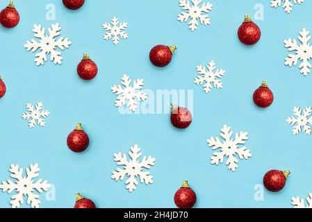 Frohe Weihnachten. Draufsicht auf kreatives Muster aus weihnachtskugeln und Schneeflocken auf blauem Hintergrund. Weihnachten Konzept Hintergrund Stockfoto