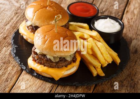 Wisconsin Butter Burger aus frisch gemahlenem Rindfleisch auf einem buttrig getoasteten Brötchen mit Käse aus nächster Nähe auf dem Holztisch. Horizontal Stockfoto