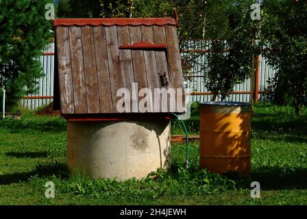 Brunnen aus Betonringen im Garten, im Sommer Stockfoto