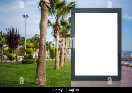 Plakatwand blank mockup und Vorlage leerer Rahmen für Logo oder Text auf der Außenseite grüne Straße Werbung Plakat Bildschirm Stadt Hintergrund. Vertikaler Leerwert wh Stockfoto