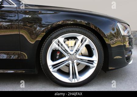 Kiew, Ukraine - 3. April 2014: Schwarzer Premium-Audi S8 in der Stadt. Ein Teil des Audi S8 auf der Hintergrundwand. Nahaufnahme von Rad und Reifen Stockfoto