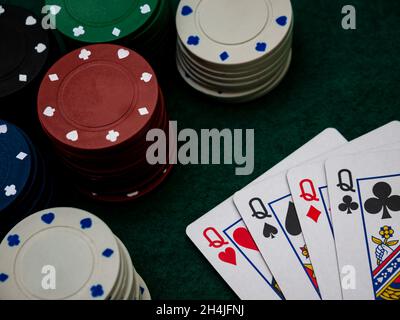 Pokerspieltisch, vier Königinnen mit Spielchips auf dem grünen Tisch Stockfoto