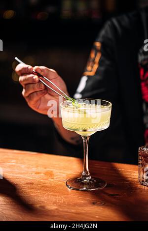 Der Barkeeper macht Cocktails in schickem Glas Stockfoto