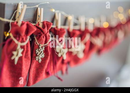 Adventskalender Rote Tüten an einem Seil hängen auf einem Kinderbett Stockfoto