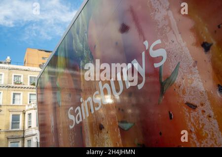 London, November 2021: Sainsburys-Logo auf der Seite des Lieferwagens. Ein großer britischer Supermarkt. Stockfoto