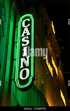 Prag, CZ - 28. oktober 2021: Prager Nachtleben Postkarte Neon Schild Casino und Restaurant auf einer altmodischen Gebäudewand mit großen Laternen. Redaktionell Stockfoto