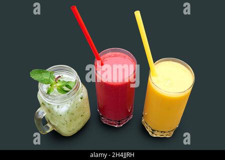 Nahaufnahme von drei verschiedenen Smoothies über dem Kopf. Isoliert auf Grau mit Beschneidungspfad Stockfoto