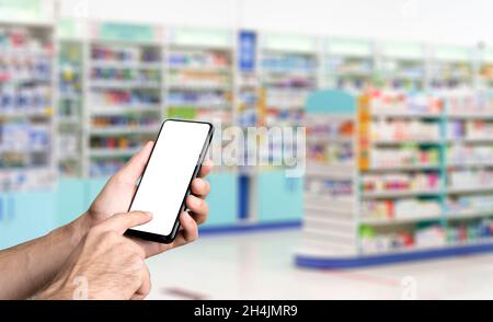 Pharmazie-Hintergrund. Blur Zähler der Apotheke mit Medikamenten, Tabletten, Pillen und Hand mit Smartphone. Hochwertige Fotos Stockfoto