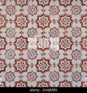 Fragment der Gebäudewand mit bunten keramischen Wandfliesen. Azulejos aus nächster Nähe. Traditionelle portugiesische Architektur. Abstrakt dekorativer Hintergrund. Stockfoto