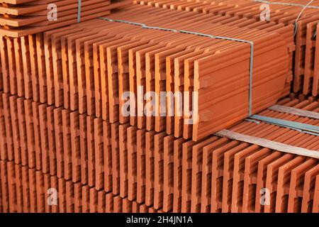 Stapel von neuen keramischen Dachziegeln auf der Baustelle. Stockfoto
