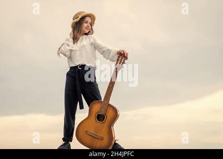 Voller Inspiration. Freiheit und Erfolg. Sängerin. Glückliche Teenager-Mädchen Gitarre im Freien spielen. Stockfoto