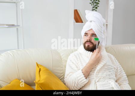 Bärtiger Mann mit Gesichtsmassage-Werkzeug. Männliches Hautpflege- und Spa-Konzept. Stockfoto