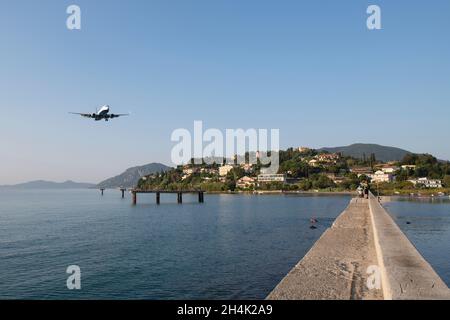 Menschen beobachten ein Flugzeug, das an Land kommt, Pontikonisi, Korfu Griechenland Stockfoto