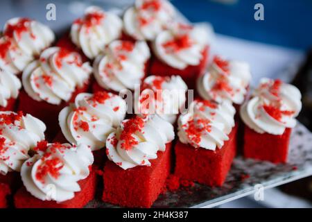 Einzelne rote Samtschwammkuchen auf einer Servierplatte Stockfoto