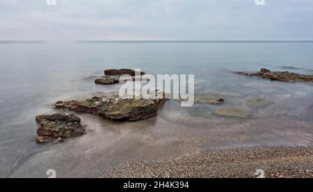 Sonnenaufgang am felsigen Strand von Sagunt. Stockfoto