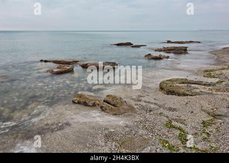 Sonnenaufgang am felsigen Strand von Sagunt. Stockfoto