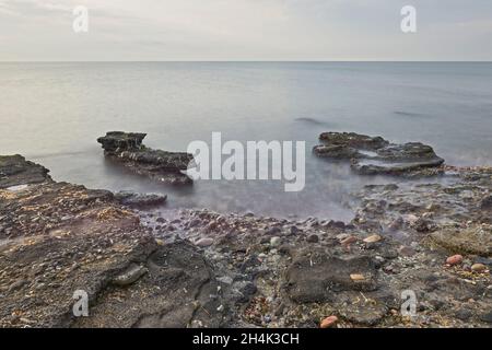 Sonnenaufgang am felsigen Strand von Sagunt. Stockfoto