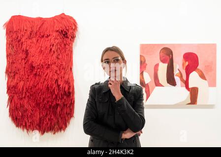 London, Großbritannien. 3. November 2021. Lauren Bevans, Kuratorin von Arbeiten des Royal College of Art Artists mit (L) „Broom Lady“ von Hoa Dung Clerget und „Our Numered Endless Days“ von Catherine Repko. Vorschau auf London Grads Now, eine Ausstellung mit über 200 Kunstwerken, die von MA-Absolventen von sieben der führenden Londoner Kunstschulen erstellt und kuratiert wurden. Die Ausstellung findet in der Saatchi Gallery vom 4. November 2021 bis zum 16. Januar 2022 statt. Kredit: Stephen Chung / Alamy Live Nachrichten Stockfoto