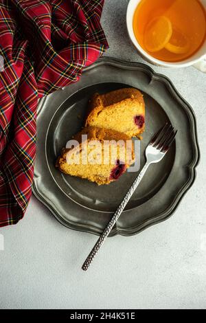 Tasse Zitronentee mit zwei Scheiben Kirschkuchen Stockfoto