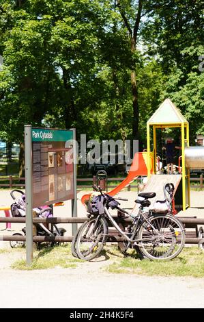 POZNAN, POLEN - 11. Jun 2017: Eine vertikale Aufnahme von aufgespannten Fahrrädern an einer Informationstafel vor einem Spielplatz im Cytadela-Park in Poznan, Pol Stockfoto