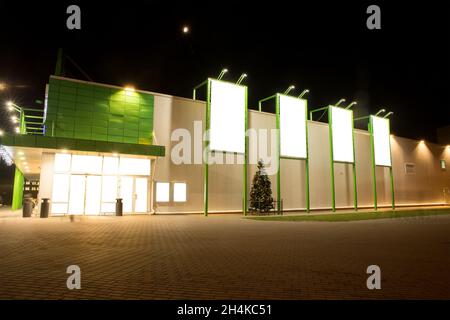 Modell. Leere Plakatwand im Freien, Außenwerbung, Schild auf modernem Gebäude des Marktes in der Nacht während der Weihnachtszeit. Stockfoto