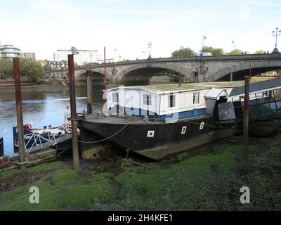 Auf der Südseite der Themse, westlich der Kew Bridge, festgemacht, mit Kräne auf der Skyline für neue Wohnungen auf der Nordseite. Stockfoto