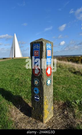 Wegmarkierung des nationalen Radnetzwerks im Campbell Park, Milton Keynes, mit der Lichtpyramide von Liliane Lijn im Hintergrund. Stockfoto