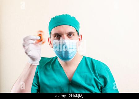 Ein Arzt in einer Maske und Handschuhen, mit einem Spinner in den Händen. Hochwertige Fotos Stockfoto