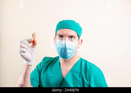 Ein Arzt in einer Maske und Handschuhen, mit einem Spinner in den Händen. Hochwertige Fotos Stockfoto