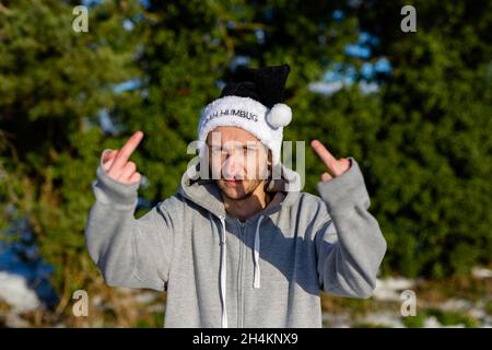 Ein mürrischer junger Mann, der einen schwarzen weihnachtsmann-Hut mit den Worten Bah Humbug trägt