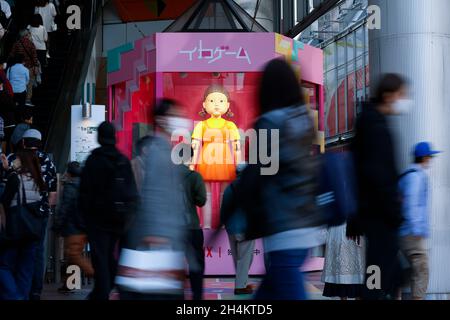 3. November 2021, Tokio, Japan: Fußgänger kommen an einer Nachbildung der „Younghee“-Puppe des südkoreanischen Netflix-Megahit-Dramas „Squid Game“ vor der Shibuya Station vorbei, einer der belebtesten Stationen der Welt. Die Statuen der Puppe und zwei Wachen in pinkfarbenen Uniformen sind im Einkaufsviertel von Shibuya installiert, wo die Menschen Fotos von der Puppe machen konnten, während sie der Stimme und der Musik des Spiels „Rotes Licht, grünes Licht“ lauschten. (Bild: © Rodrigo Reyes Marin/ZUMA Press Wire) Stockfoto