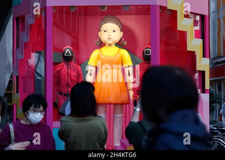 3. November 2021, Tokio, Japan: Fußgänger kommen an einer Nachbildung der „Younghee“-Puppe des südkoreanischen Netflix-Megahit-Dramas „Squid Game“ vor der Shibuya Station vorbei, einer der belebtesten Stationen der Welt. Die Statuen der Puppe und zwei Wachen in pinkfarbenen Uniformen sind im Einkaufsviertel von Shibuya installiert, wo die Menschen Fotos von der Puppe machen konnten, während sie der Stimme und der Musik des Spiels „Rotes Licht, grünes Licht“ lauschten. (Bild: © Rodrigo Reyes Marin/ZUMA Press Wire) Stockfoto