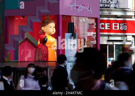 3. November 2021, Tokio, Japan: Fußgänger kommen an einer Nachbildung der „Younghee“-Puppe des südkoreanischen Netflix-Megahit-Dramas „Squid Game“ vor der Shibuya Station vorbei, einer der belebtesten Stationen der Welt. Die Statuen der Puppe und zwei Wachen in pinkfarbenen Uniformen sind im Einkaufsviertel von Shibuya installiert, wo die Menschen Fotos von der Puppe machen konnten, während sie der Stimme und der Musik des Spiels „Rotes Licht, grünes Licht“ lauschten. (Bild: © Rodrigo Reyes Marin/ZUMA Press Wire) Stockfoto