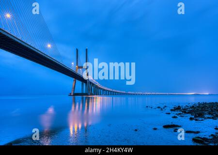 Die Vasca da Gama Brücke über den Fluss Tejo in Lissabon, Portugal, bei Dämmerung Stockfoto