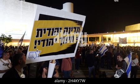 Ein israelischer rechter Protestler hält ein Schild mit der Aufschrift „jüdischer Staat, jüdische Bildung“, während sich rechtsgerichtete Aktivisten und Likud-Parteianhänger versammeln, um gegen die Regierungspolitik zu protestieren und am 02. November 2021 in Tel Aviv, Israel, den Oppositionsführer Benjamin Netanjahu als Premierminister auf dem Habima-Platz wieder einzusetzen. Nationalreligiöse Aktivisten und jüdische Siedler verlassen den rechten Premierminister Naftali Bennett wegen seiner Partnerschaft mit zentristischen und linken Parteien. Stockfoto