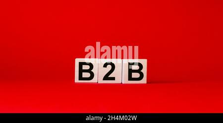 Akronym B2B – Business to Business. Holzwürfel mit Buchstaben isoliert auf rotem Hintergrund. Image des Geschäftskonzepts. Stockfoto