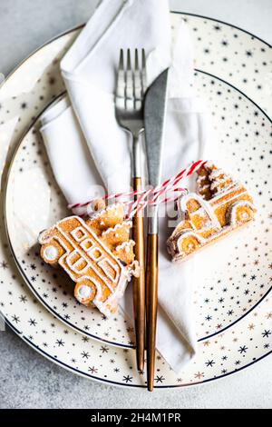 Minimalistische Tischeinstellung für Weihnachtsessen auf weißem Betontisch Stockfoto