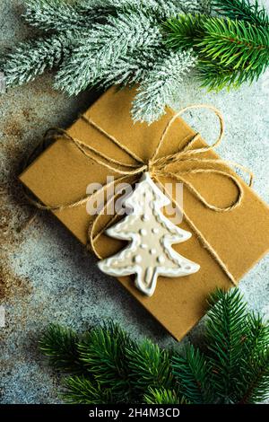 Geschenkbox mit rustikalem Band und Keramik-Dekor mit Tannenbaum auf Beton Hintergrund dekoriert Stockfoto