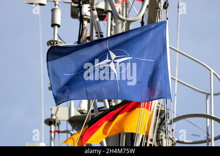 Flagge der Organisation des Nordatlantikvertrags (NATO), die im Wind auf dem Mast eines Kriegsschiffs fliegt Stockfoto