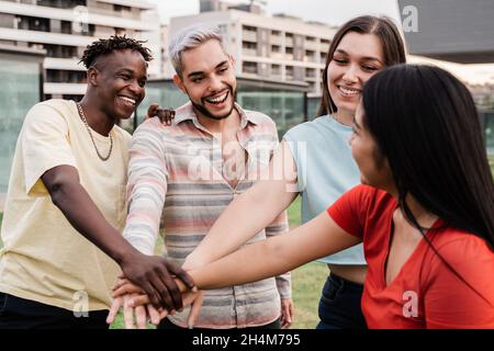 Junge verschiedene Gruppe von Menschen feiern zusammen Stapeln Hände im Freien - Fokus auf Homosexuell Mann trägt Make-up Stockfoto