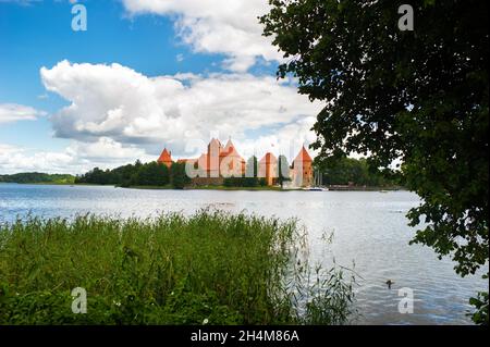 Litauen. Blick auf Trakai Burg über See und weiße Yacht unter Segel. Stockfoto