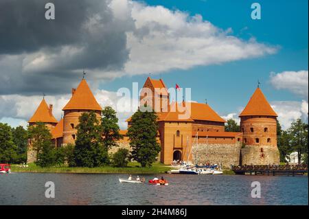 Litauen. Blick auf Trakai Burg über See und weiße Yacht unter Segel. Stockfoto