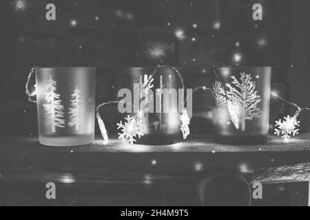 Winterszene mit Glas-Kerzenhaltern mit Bäumen und Schneeflocken-Lichtern zur Dekoration Stockfoto