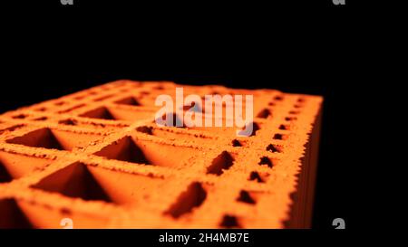 Bau- und Materialkonzept. Abstrakte Animation der orangefarbenen 3d-Ziegeloberfläche auf dem schwarzen Hintergrund. Stockfoto