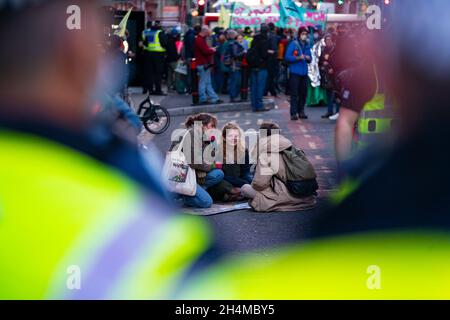 Glasgow, Schottland, Großbritannien. November 2021. Am 4. Tag der UN-Klimakonferenz in Glasgow gab es Demonstrationen der Extinction Rebellion-Protestgruppe im Stadtzentrum von Glasgow. Nachdem sie von der Polizei gejagt wurden, veranstalteten sie eine Sitzveranstaltung, um gegen die Blockierung der St. Vincent Street zu protestieren. Demonstranten wurden später kettiert und durch die Stadt eskortiert und durften am Veranstaltungsort COP26 in Finnieston vorbeilaufen. Iain Masterton/Alamy Live News. Stockfoto