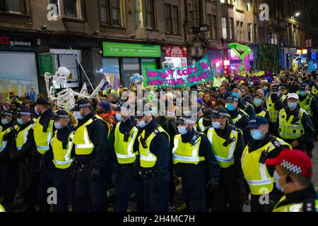 Glasgow, Schottland, Großbritannien. November 2021. Am 4. Tag der UN-Klimakonferenz in Glasgow gab es Demonstrationen der Extinction Rebellion-Protestgruppe im Stadtzentrum von Glasgow. Nachdem sie von der Polizei gejagt wurden, veranstalteten sie eine Sitzveranstaltung, um gegen die Blockierung der St. Vincent Street zu protestieren. Demonstranten wurden später kettiert und durch die Stadt eskortiert und durften am Veranstaltungsort COP26 in Finnieston vorbeilaufen. Iain Masterton/Alamy Live News. Stockfoto