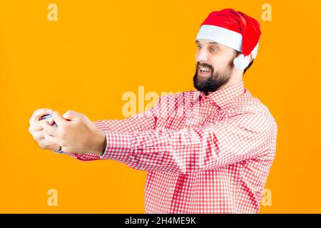 Bärtiger Mann mit Weihnachtshut der Weihnachtsmann macht ein Neujahrs-Selfie Stockfoto