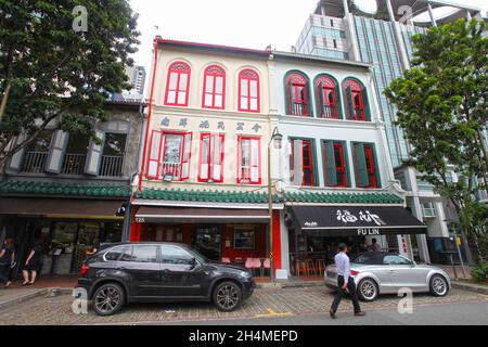 Alte Geschäftshäuser in der Telok Ayer Street in Singapurs Chinatown-Viertel mit Menschen, die auf der Straße spazieren. Stockfoto