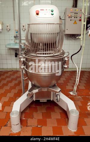 Der Prozess der Herstellung von Plätzchenteig in einer industriellen Knetmaschine in der Fabrik. Stockfoto